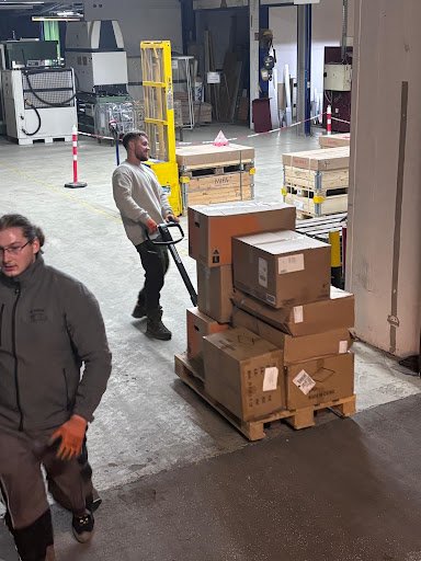 Mitarbeiter transportiert Paletten im Lager