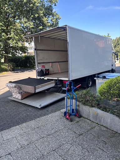 Sofa wird über eine Laderampe in den Möbelwagen geladen