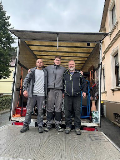 Drei Mitarbeiter von MP Transporte am Möbelwagen